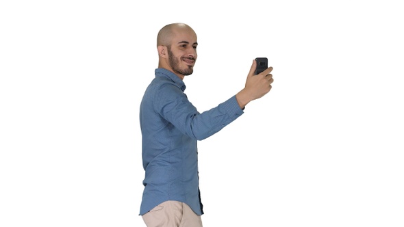 Happy smiling handsome young man making selfie while walking