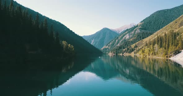 Beautiful landscape of mountain lake, Emerald water surrounded by coniferous forest, autumn grass