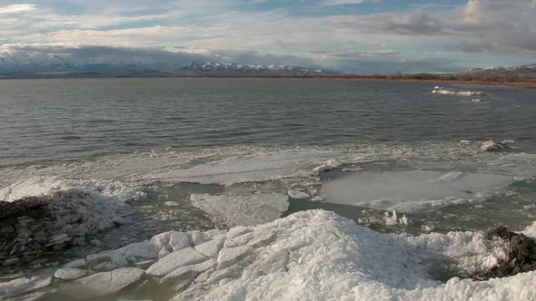 Flying backwards over lake revealing piles of ice