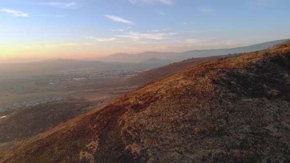 Aerial rotating shot of a large mountain near Colima in Mexico at sunset.