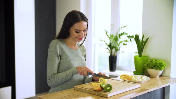 Healthy Lifestyle. Woman Cutting Fresh Fruits At Kitchen