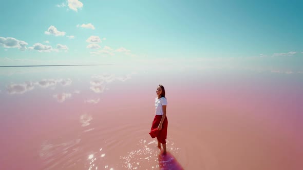 Slow Motion of Woman Traveler Standing Inpink Water with Beautiful Mirror Reflection of Blue Sky on