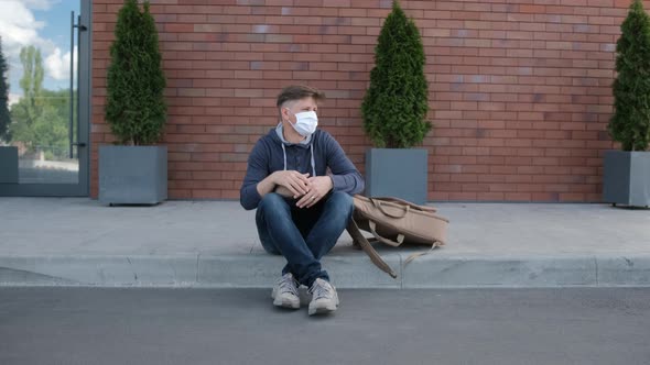 Young Man with a Medical Mask Looked Around and Stand Up To Go