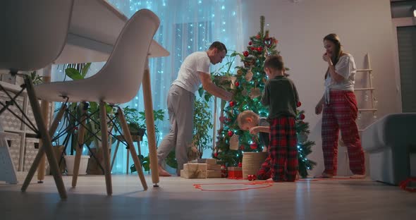 The Family Decorates the Christmas Tree Together