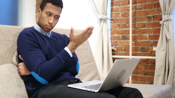 African Man Thinking and Working on Laptop, Relaxing on Sofa