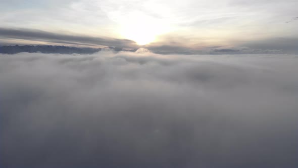 Incredible Aerial View Shot Above Swirling Fog and Clouds at Sunset in the Mountains