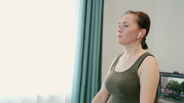 A Woman at Home with Dumbbells in Her Hands Performs Exercises