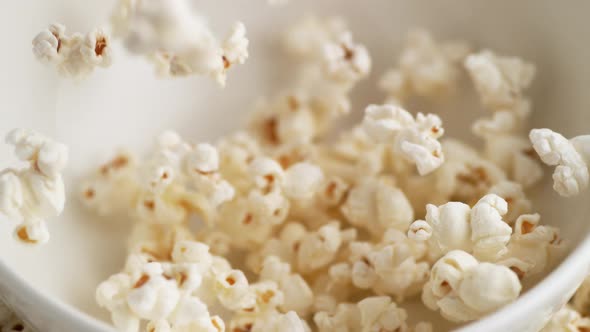 Tossing popcorn into a bowl. Slow Motion. alt