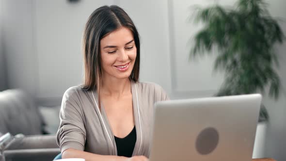 Smiling Young Woman Chatting on Laptop Smiling Having Positive Emotion