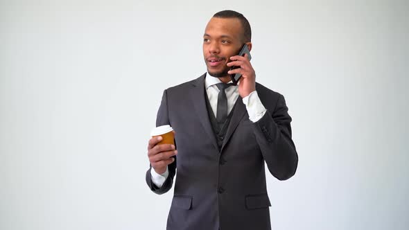 Professional African-american Business Man Holding Cup of Coffee Talking on Mobile Phone