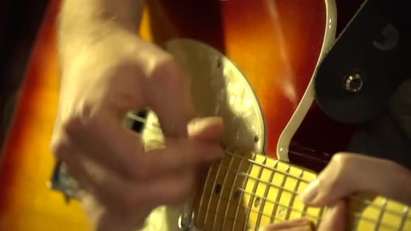 Close up shot of a man playing an electric guitar.