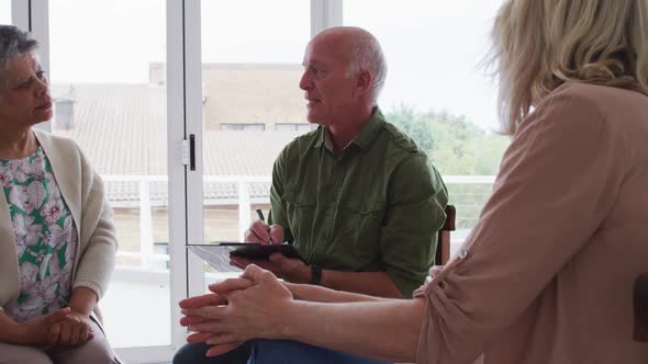 Two diverse senior couples sitting in circle having a therapy conversation at home