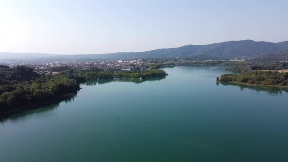 Panoramic view over a beautiful landscape with a natural lake surrounded by trees, and a town nearby