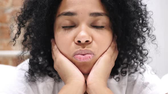 Happy AfroAmerican Woman Lying in Bed Smiling While Looking in Camera