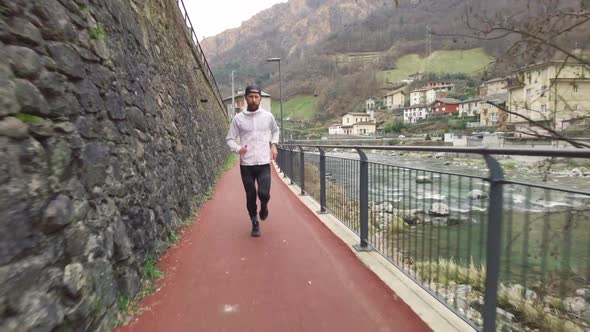 A Man With A Beard Runs On A Narrow Bike Path