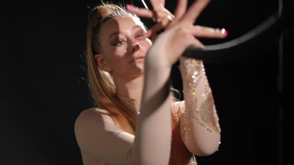 Portrait of Confident Serious Beautiful Woman Putting Hands on Air Hoop Looking at Camera Hiding