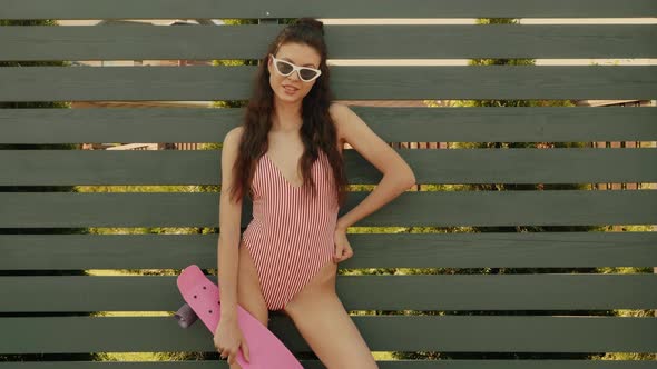 Young beautiful sexy smiling hipster woman in sunglasses posing outdoors