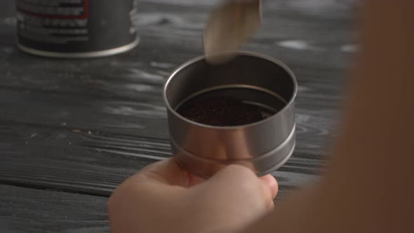 Woman Filling the Funnel of Moka Pot with Ground Coffee