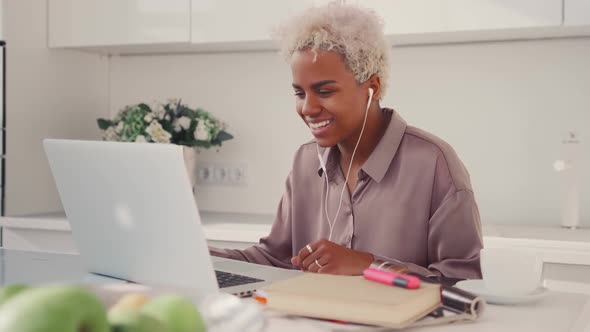 Happy African American Female Student Waving Hello at Laptop Webcam