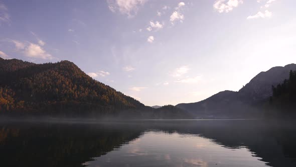 Silent Water of Autumn Mountain Lake with Boats Slowly Sailing on Background