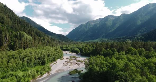 Landscape of a Mountain River in Green Mountains with White Clouds