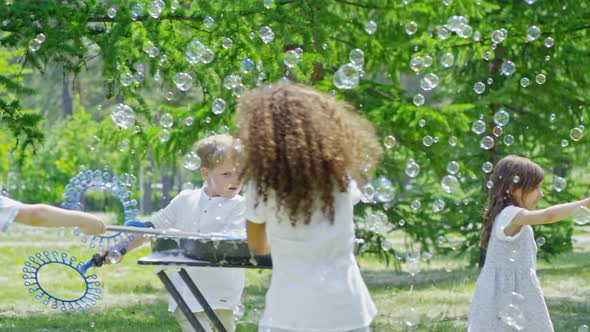 Adorable Kids Playing with Soap Bubbles in Park alt