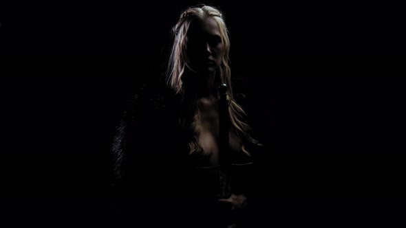 Medieval Warrior Woman with a Sword Is Standing in the Dark, Viking, Blonde