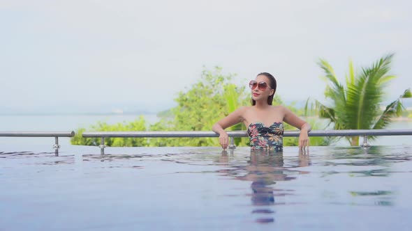 Young asian woman enjoy around outdoor swimming pool for leisure