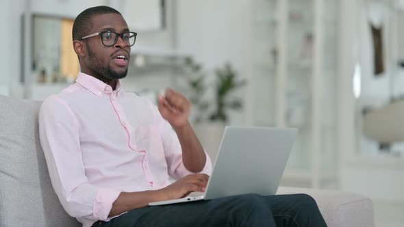 Sick African Man with Laptop Coughing at Home