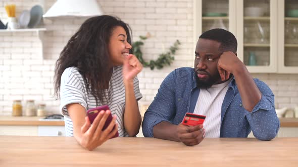 The Multiracial Couple Using a Smartphone for Shopping Online at Home