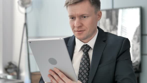 Businessman Celebrating Success on Tablet