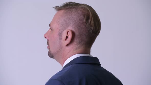 Rear View of Blonde Businessman Looking Back