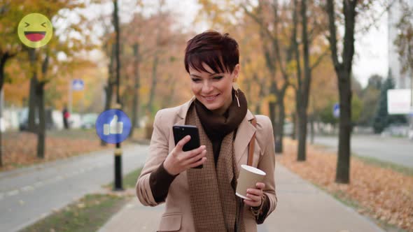 A Woman Uses a Smartphone on the Street.