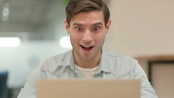 Close Up of Creative Young Man Celebrating Success on Laptop