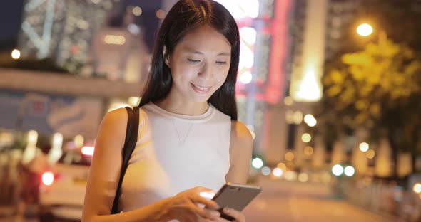 Woman using mobile phone at night 