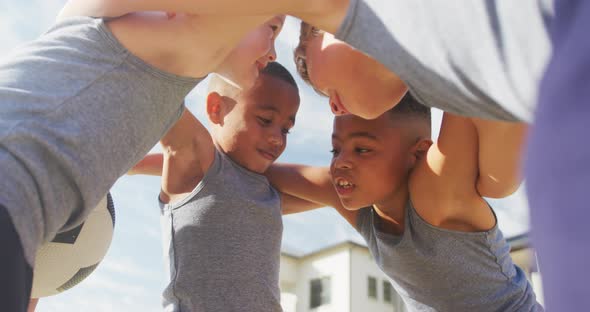 Video of happy diverse boys holding arms and talking