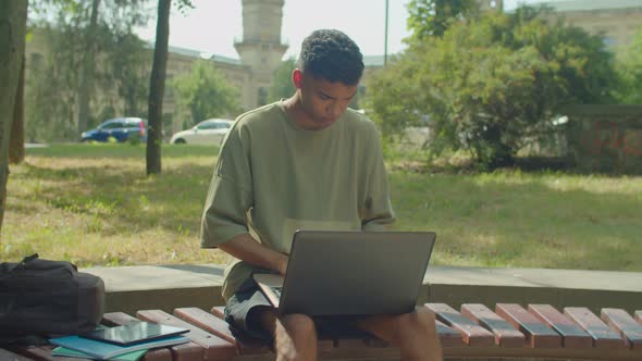 Thoughtful African Male Student with Laptop Pc Learning at University Campus