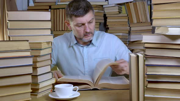 A Bearded Man Reads a Book in the Library