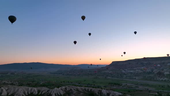 4K Aerial view of Goreme. Colorful hot air balloons fly over the valleys.