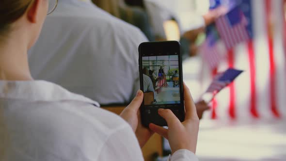 Businesswoman clicking photo of speaker with mobile phone in a political campaign 4k