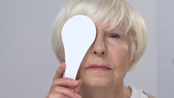 Upset Elderly Woman Squinting Eyes on Ophthalmological Examination