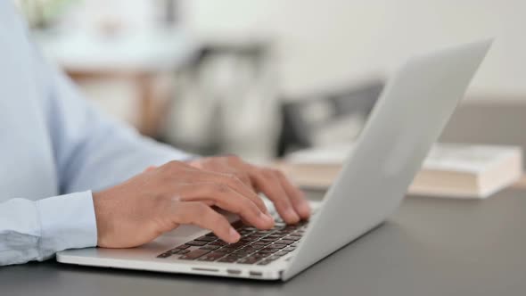 African Man Hands Typing on Laptop Close Up