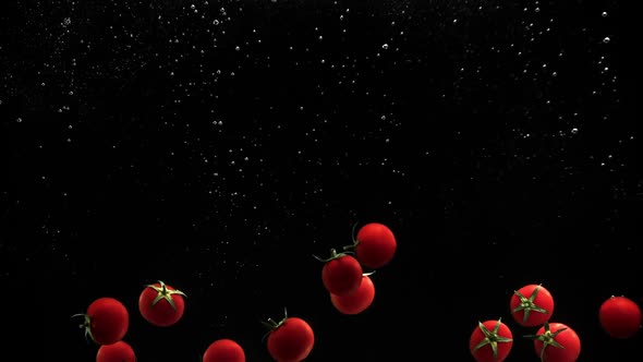 Fresh Vegetables Cherry Tomatoes Falling in Water on Black Background