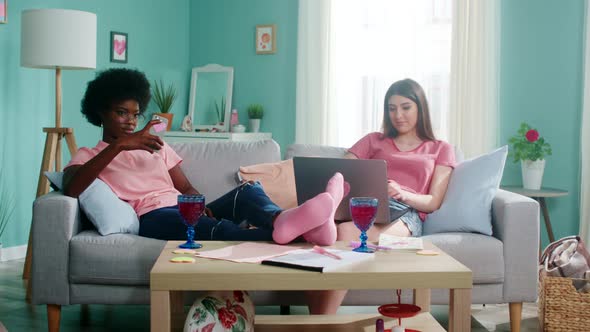 Two Women Students Stay Home And Use Gadgets