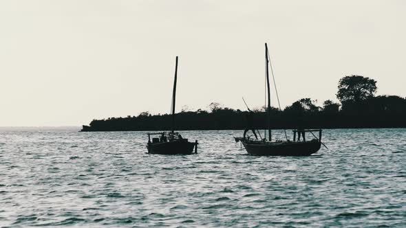 Silhouettes African Wooden Dhow Boat with Fishermen Floating By Ocean Zanzibar