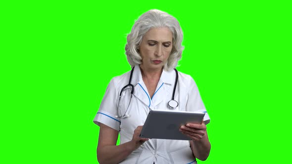 Serious Doctor with Tablet Pc on Green Screen