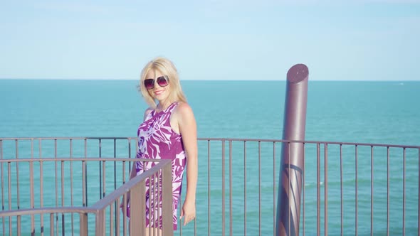 Happy Girl Moves on a Viewing Tower in Front of the Sea