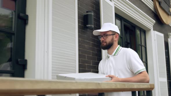 Cheerful Courier Carrying Boxes of Pizza