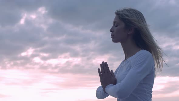 young woman in meditation near the sea: practicing yoga