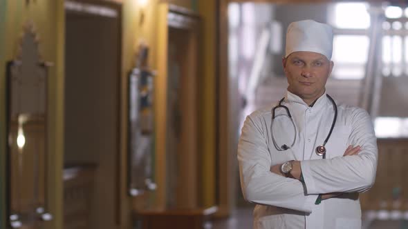 Portrait of a male doctor satisfied with his work in a hospital corridor. The concept of medicine